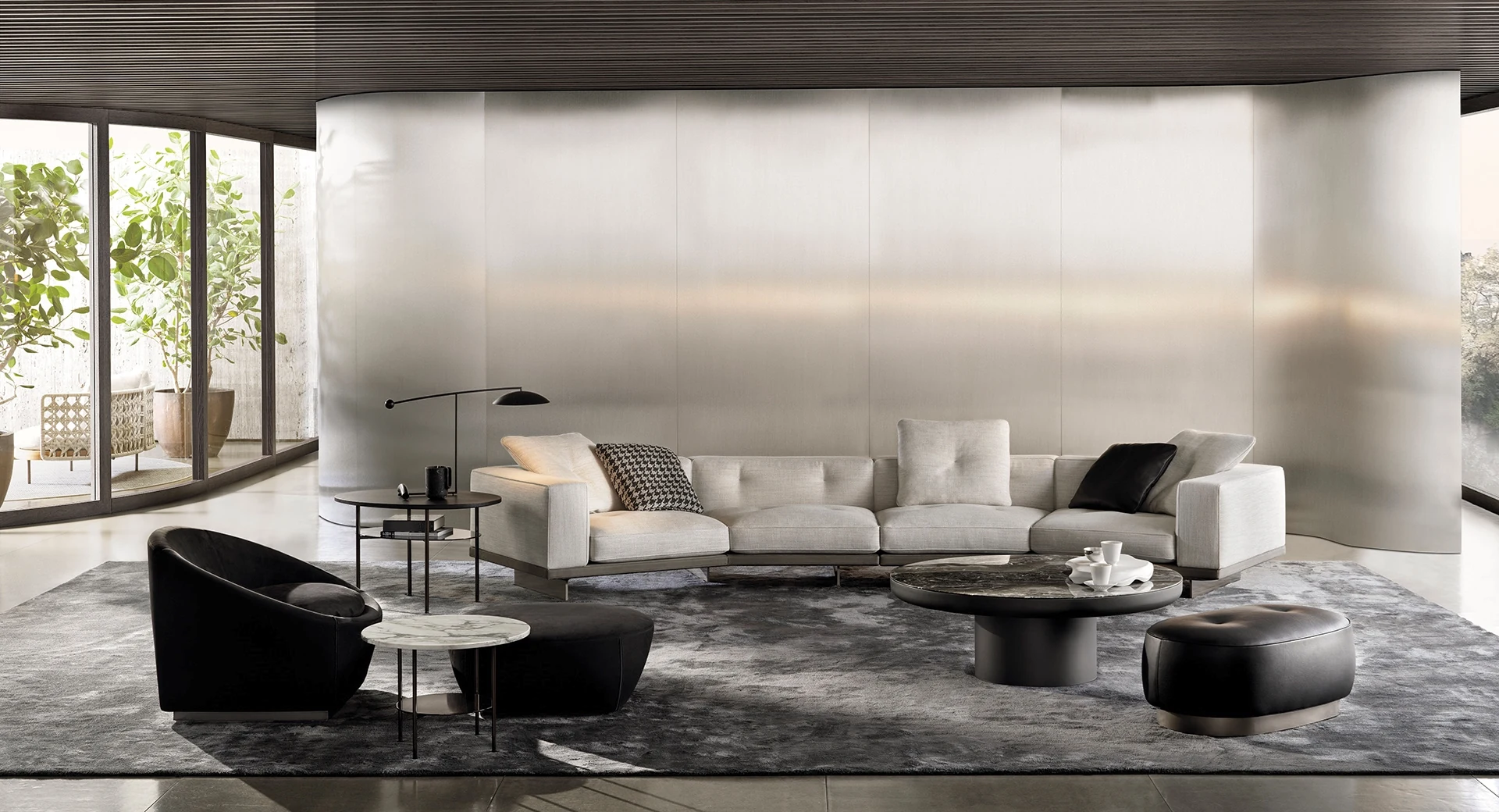 Minotti Dylan cream sectional sofa with sculptural black chairs and coffee tables in a contemporary living room