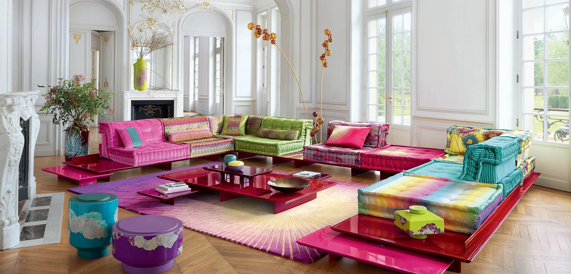Colourful Roche Bobois Mah Jong modular sofas in a bright room with ornate white walls